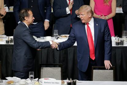 Donald Trump (r) shakes hands with John Paulson during a meeting of the Economic Club of New York in New York, Nov. 12, 2019.