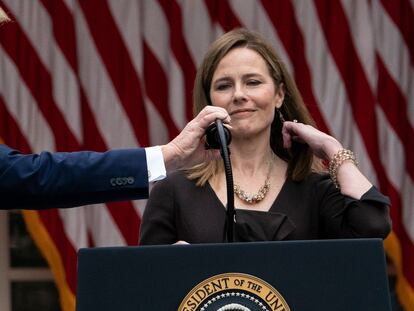 Donald Trump ajusta el micrófono a la magistrada Amy Coney Barrett, durante su nombramiento en la Casa Blanca, el pasado 26 de septiembre.
