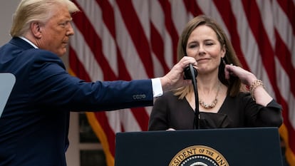 Donald Trump ajusta el micrófono a la magistrada Amy Coney Barrett, durante su nombramiento en la Casa Blanca, el pasado 26 de septiembre.