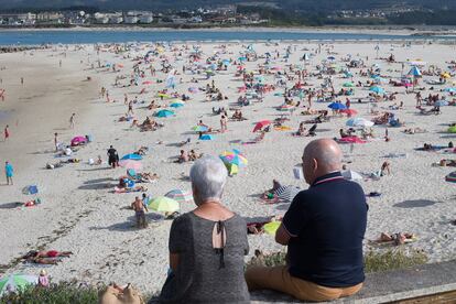 Dos personas observan la playa en A Mariña, en Lugo, este lunes.
