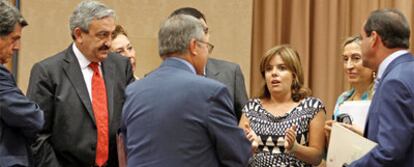 Bono, primero por la derecha, y  Soraya Sáenz de Santamaría, tercera,  hablan con diputados del PP, ayer en el  Congreso.