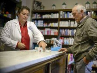 Un farmaceútico atiende a un cliente en su farmacia. EFE/Archivo