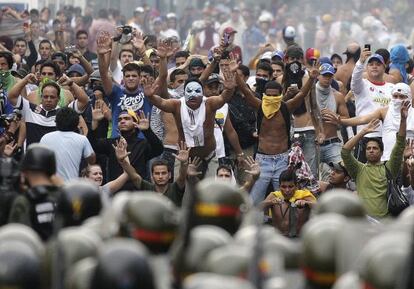 Supporters of Capriles face off with riot police in Caracas on Tuesday.