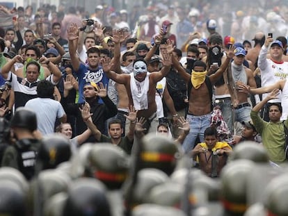 Supporters of Capriles face off with riot police in Caracas on Tuesday.