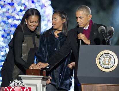 El presidente estadounidense, Barack Obama, enciende las luces del árbol de Navidad con su esposa Michelle y a su hija pequeña, Sasha.