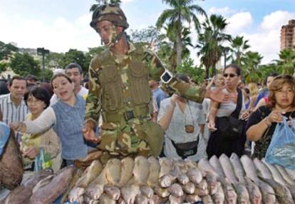 Un militar venezolano vende pescado en uno de los mercados organizados por el Gobierno de Chávez.