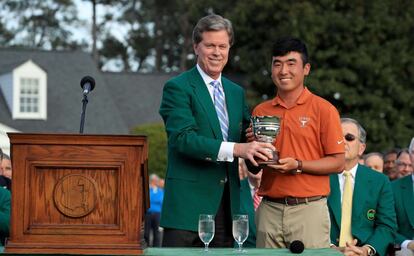 El estadounidense Patrick Reed se llevó la gloria y el primer grande de su carrera a los 27 años después de resistir en cabeza con -1 en el día para -15 en total. En la imagen, Doug Ghim (derecha) recibe el premio amater.