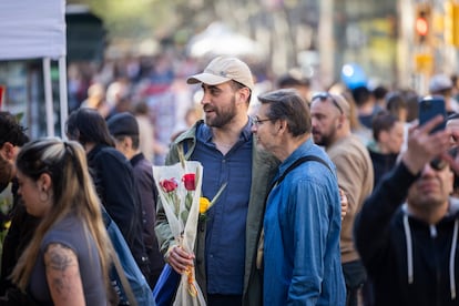 Gente pasea por la feria de Sant Jordi en busca de libros que comprar.