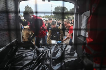 Voluntarios de la Cruz Roja colocan los cuerpos de las personas muertas por el ataque ruso.