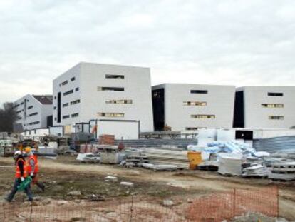 Unos trabajadores caminan por las obras del futuro hospital de Collado Villalba.