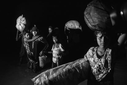 Una familia de refugiados rohingya camina de noche por el agua después de llegar en barco a la orilla bangladesí del río Naf.  "ARSA no tiene otra opción que combatir el 'terrorismo patrocinado por el estado birmano' contra la población rohingya con el propósito de defender, rescatar y proteger a la comunidad rohingya", ha asegurado el grupo en un comunicado firmado por Ata Ulá, el líder de uno de los principales grupos insurgentes rohingya.