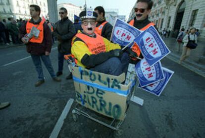 Unos agentes realizan una parodia con el 'nuevo coche patrulla' de la policía de barrio de Madrid, durante la manifestación.