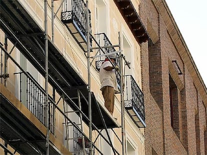 Un obrero, asomado a un andamio en el barrio de las Letras, en el centro de la capital.