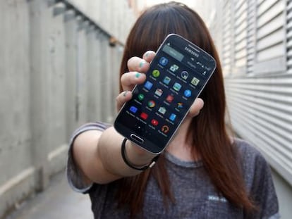 Una joven muestra la pantalla de su teléfono inteligente.