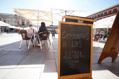 Una pizarra anuncia el nuevo horario de uno de los bares de la plaza de la Corredera en Córdoba.