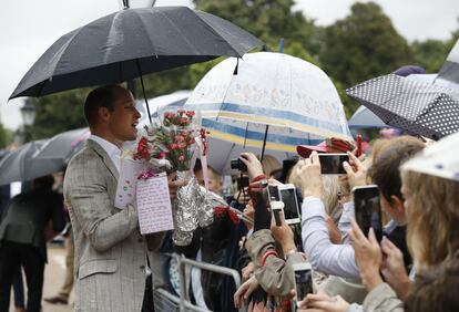 El príncipe Guillermo recoge flores de mano de las personas que se han acercado a homenajear a Diana de Gales a las puertas del palacio de Kensington.