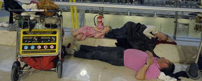 Una familia duerme en las instalaciones de Barajas a la espera de que su vuelo pueda despegar tras los retrasos provocados por la nieve.