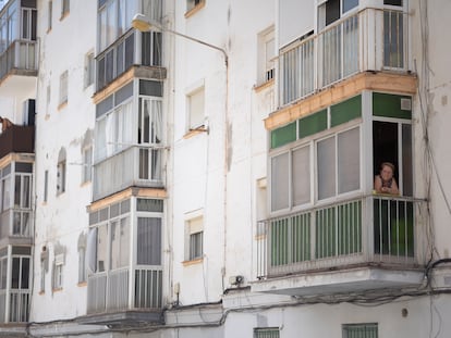 Una vecina se asoma al balcón de su piso en uno de los edificios afectados en el Cerro del Moro (Cádiz).
