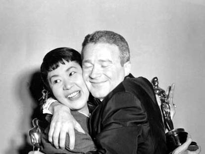 Miyoshi Umeki y Red Buttons se abrazan al conseguir su Oscar en 1958.