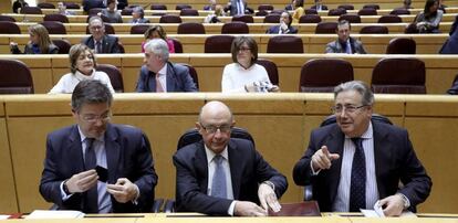 Los ministros de Justicia, Rafael Catalá (i), Hacienda, Cristóbal Montoro (c) e Interior, Juan Ignacio Zoido, durante el pleno celebrado el 20 de marzo en el Senado, en Madrid.