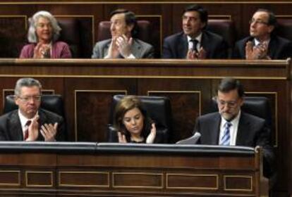 El presidente del Gobierno, Mariano Rajoy; la vicepresidenta, Soraya Sáenz de Santamaría, y el ministro de Justicia, Alberto Ruiz Gallardón, hoy, en la Sesión Plenaria del Congreso.