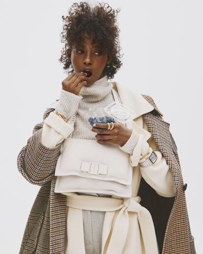Abrigo de cachemir de pata de gallo de The Weeknd, abrigo de lana crudo de Uniqlo, jersey de lana con cuello alto de Dsquared, pantalón de lino rústico de Cos, bolso monocolor de piel con cadena de Salvatore Ferragamo, brazalete ancho de oro de Tiffany, reloj, pulsera y sortija de oro, todo de Cartier.