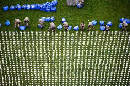 Voluntarios del primer batallón de los 'Royal Anglians' ayudan a colocar algunas de las 72,396 figuras que forman parte de la exposición 'Shroud of the Somme', en el Queen Elizabeth Olympic Park de Londres.