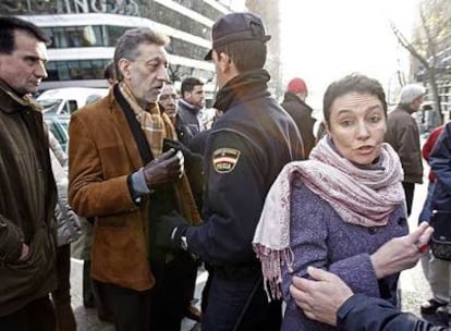 El presidente del PCTV, Juan Carlos Ramos, frente a un policía ante la Audiencia Nacional. A la derecha, la abogada Jone Goirizelaia.