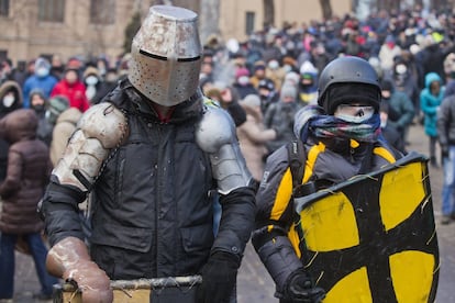 Los manifestantes con unas protecciones improvisadas, se preparan para un enfrentamiento con la policía en el centro de Kiev, Ucrania, lunes, 20 de enero de 2014. 