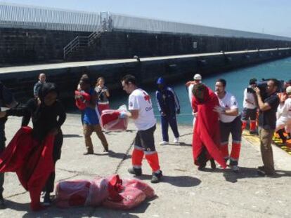 Voluntarios de Cruz Roja y guardias civiles atienden a los inmigrantes rescatados este s&aacute;bado por Salvamento Mar&iacute;timo.