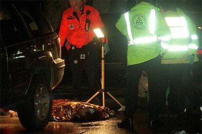 El cadáver de una de las víctimas tras un tiroteo entre bandas mafiosas en la calle madrileña de Jazmín.