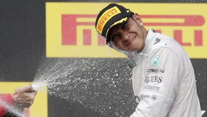 Lewis Hamilton es rociado con champ&aacute;n en el podio de Hungr&iacute;a.