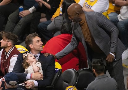 Pau Gasol sujeta a su hija mientras saluda a la leyenda del baloncesto James Worthy durante el partido del martes.