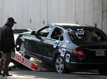 La policía científica inspecciona el coche donde viajaban los dos secuestrados y el joven asesinado