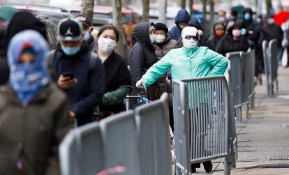 La gente espera en una fila larga para recoger comida en un banco de alimentos en Nueva York, EE. UU.