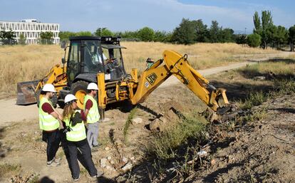 Los arqueólogos de la empresa ArqueAntro junto a la retroexcavadora en el primer día de búsqueda de la posible fosa común en el barrio de Montecarmelo.