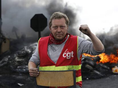 Un sindicalista mira a c&aacute;mara tras crear una barricada para impedir el acceso a una refiner&iacute;a durante la huelga en Douchy les Mines, al norte de Francia.