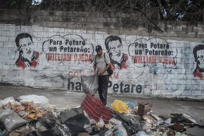 Un hombre recoge la basura en el barrio de Petare, en Caracas.