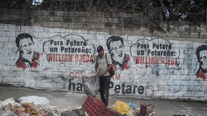 Un hombre recoge la basura en el barrio de Petare, en Caracas.