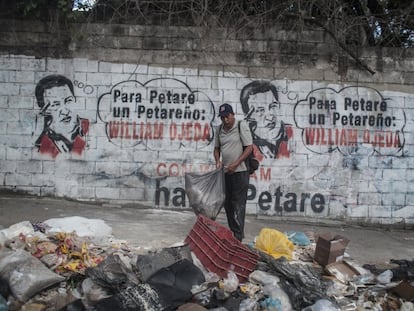 Un hombre recoge la basura en el barrio de Petare, en Caracas.