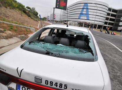 Los taxistas que siguen trabajando utilizan el aparcamiento de llegadas de la T-4 como alternativa para evitar los piquetes, pero los manifestantes lo ven y acuden a destrozar los cristales de uno de los vehículos. Mientras los usuarios caminan por la carretera.