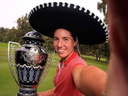 Carlota Ciganda finge un selfie con el trofeo de campeona del torneo de México.