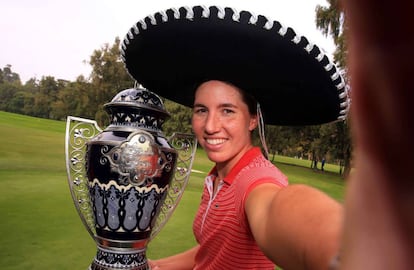 Carlota Ciganda finge un selfie con el trofeo de campeona del torneo de México.