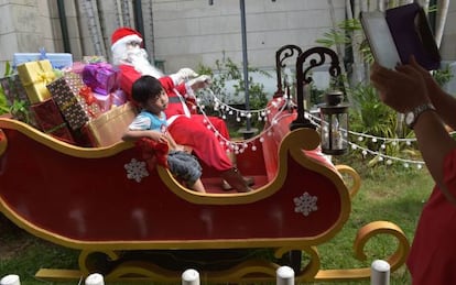Un niño subido a un trineo de Papá Noel en Yakarta.