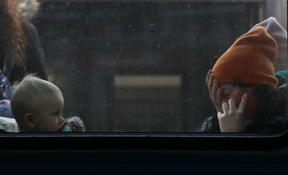 Una mujer y su hijo aguardan en el interior de un tren en la Estación Central de Lviv (Ucrania) para poner rumbo a Polonia. Naciones Unidas ha hecho un llamamiento urgente de ayuda humanitaria a la comunidad internacional por una cuantía de 1.700 millones de dólares (unos 1.530 millones de euros), de los que 550 millones de dólares (495 millones de euros) se destinarían a socorrer (desde un lugar donde dormir hasta ayuda psicológica) a los ucranios ―en su gran mayoría mujeres y niños― que escapan de la guerra.