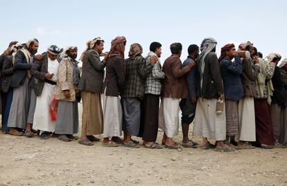 Víctimas de la guerra hacen cola para recibir raciones de alimentos de emergencia, el día 8 en la provincia de Amran, Yemen.