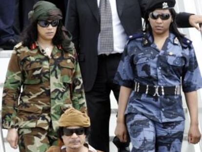 Gadafi, escoltado por su guardia de seguridad femenina en el aeropuerto de Ciampino, cerca de Roma, en 2010.