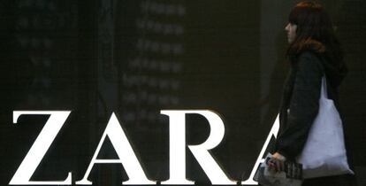 Una mujer joven pasa delante de una tienda de la cadena Zara