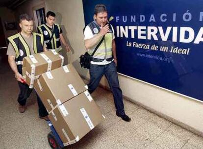 Agentes de la policía judicial retiran documentación de la sede de Intervida cuando fue intervenida, el mes pasado.