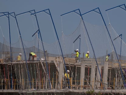 Varios empleados de la construcción trabajan en un edificio de viviendas, en Sevilla.